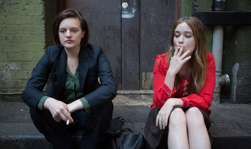 Two women sitting on a stoop smoking