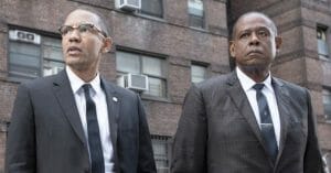 Two men standing outside a brick building